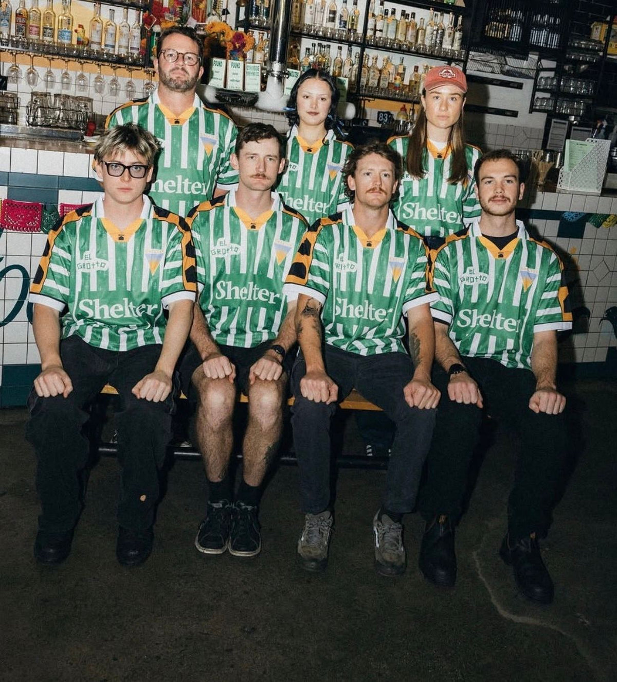 Venue bar staff wearing custom Shelter and El Grotto team jerseys