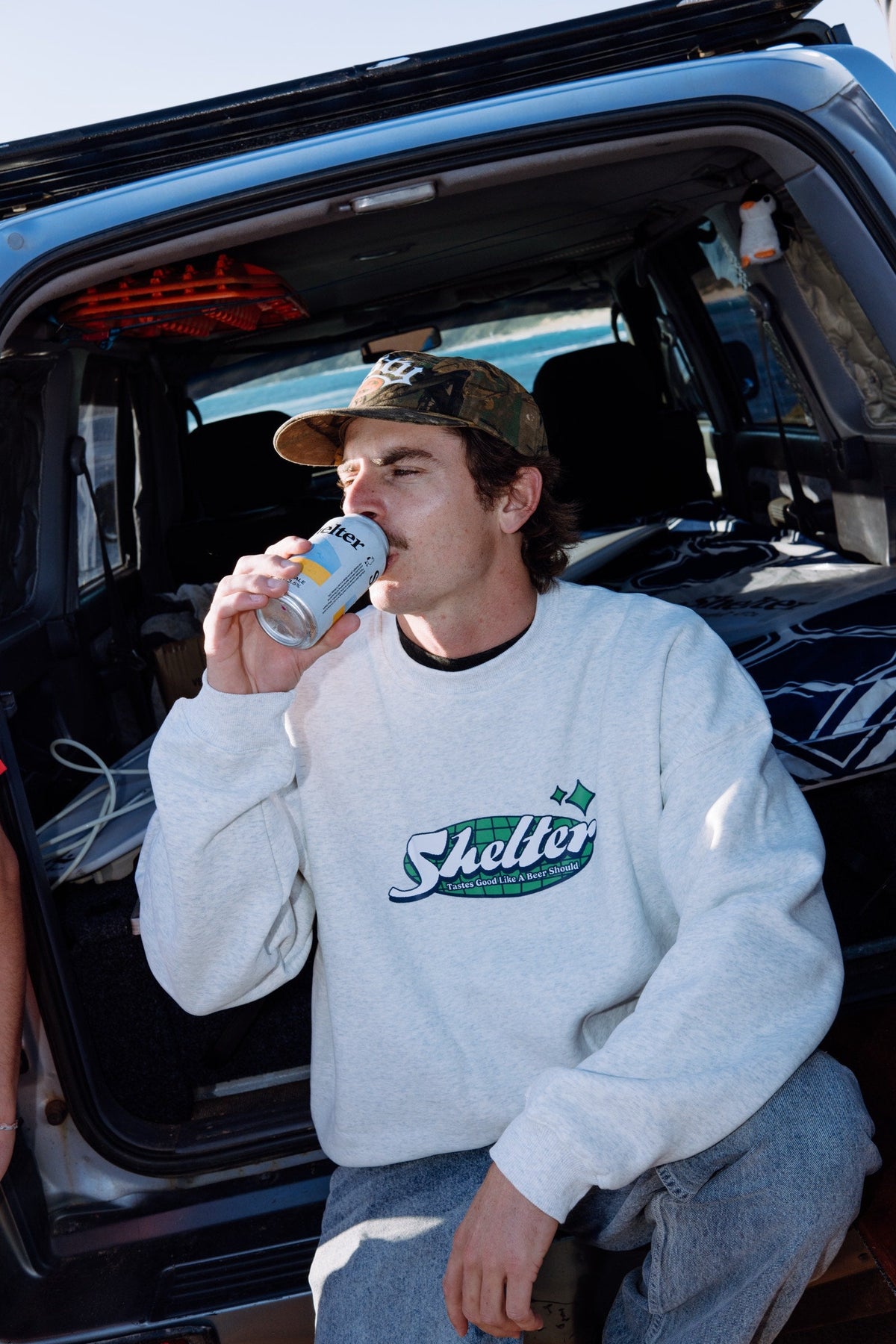 Shelter screen printed crew sweatshirt worn at the back of a wagon on the coast