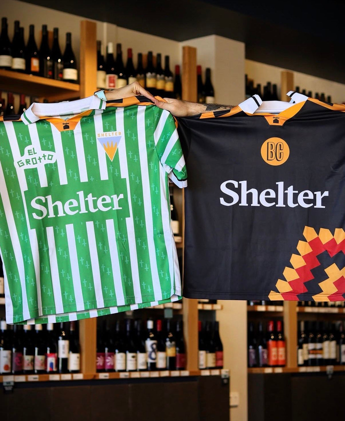 Custom screen printed jerseys produced for Shelter and El Grotto, displayed together in a bottle shop